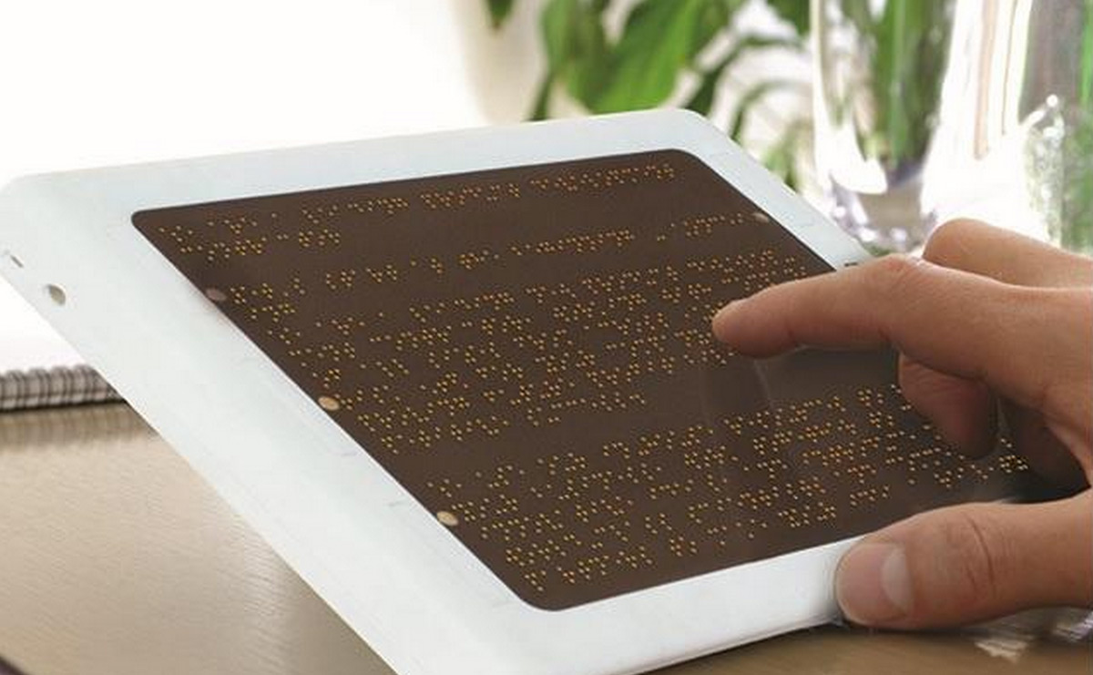 Braille display converting a website's text to braille with user's fingers running over it.